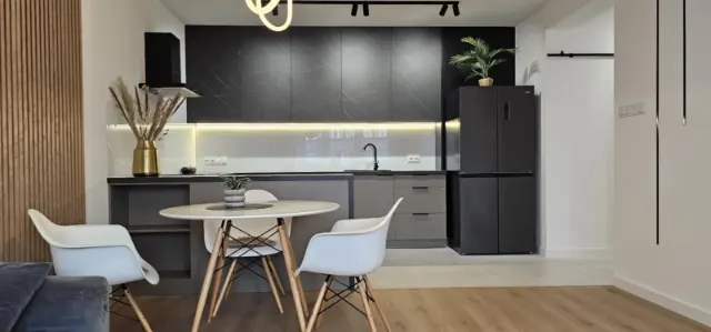 Apartament z czarną kuchnią, kuchnia w czarnym kamieniu z dębową ścianą lamelową